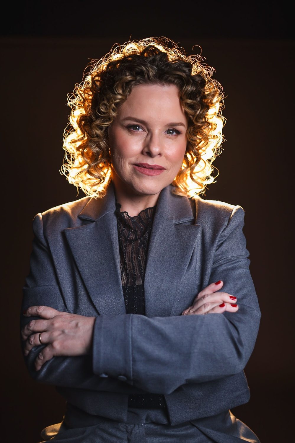 Gabriella Parra de braços cruzados, com o cabelo iluminado por trás